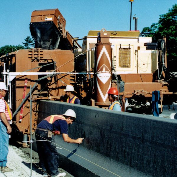 Installing tall wall concrete median barriers on the highway (1990s, Source: Miller Paving)