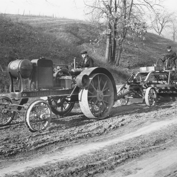 Waterloo boy on tractor with steel wheels pulling an operated pull grader 1920s